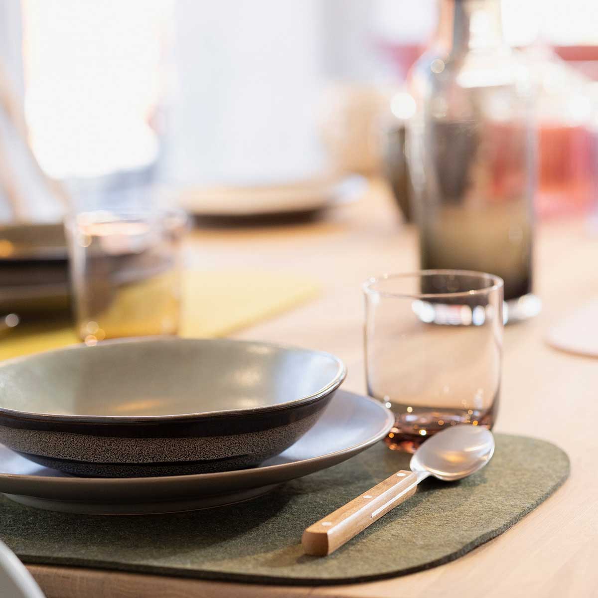 Gedeckter Tisch mit disana Filz-Tischset in Oliv, Keramikgeschirr und Besteck mit Holzgriff, Wollfilz aus Bio-Merinowolle