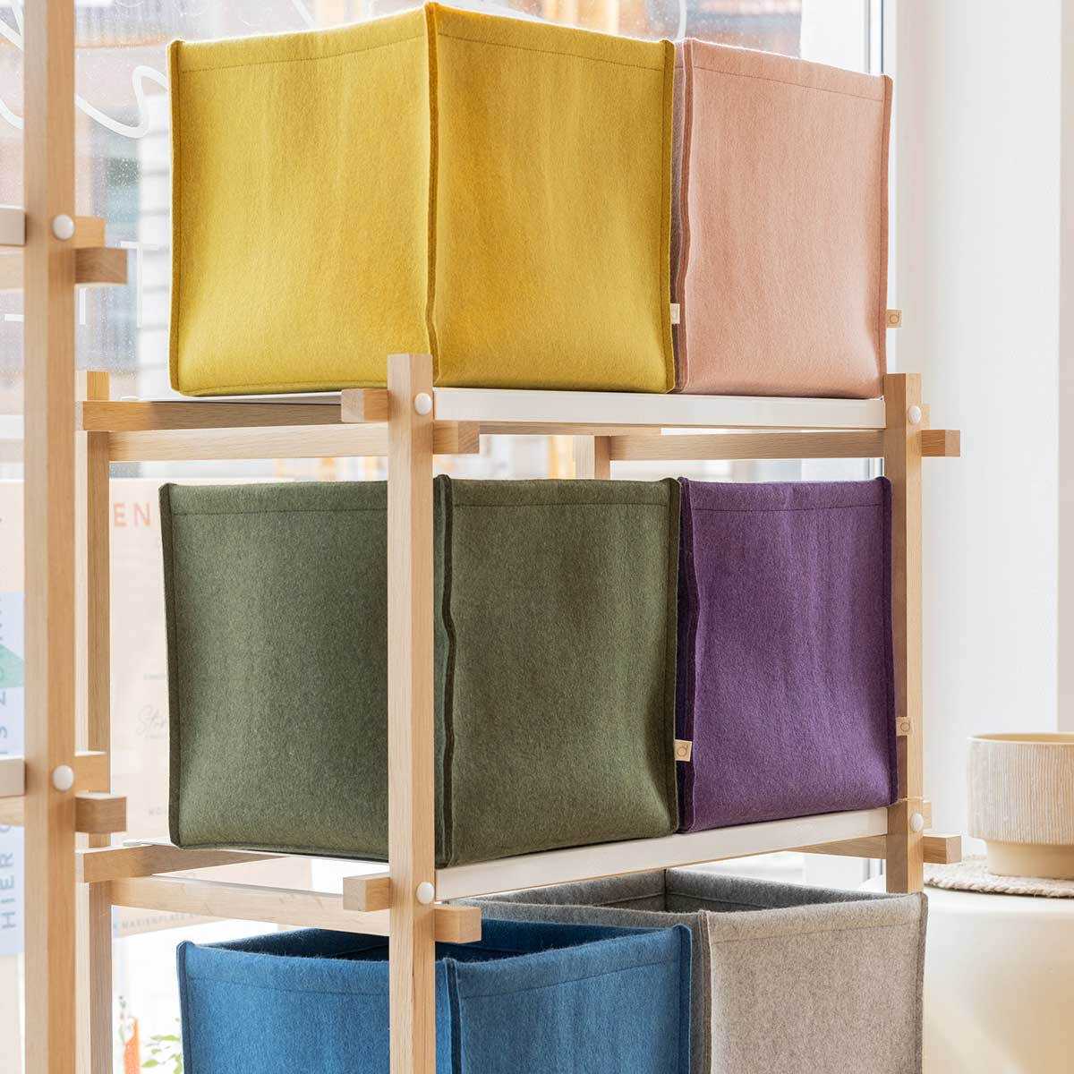 Felt storage boxes in various colours on a shelf