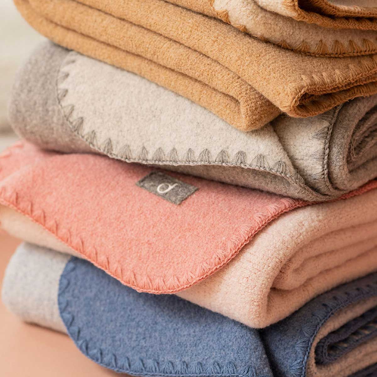 Stacked boiled wool blankets in various colours