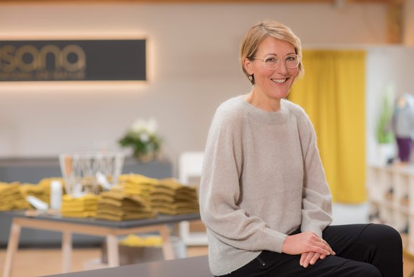 Porträt der Marketing- und Ladenleitung Renate Höcht-Sautter im hellen Langarm-Pullover, lächelnd im disana Laden in Holzelfingen