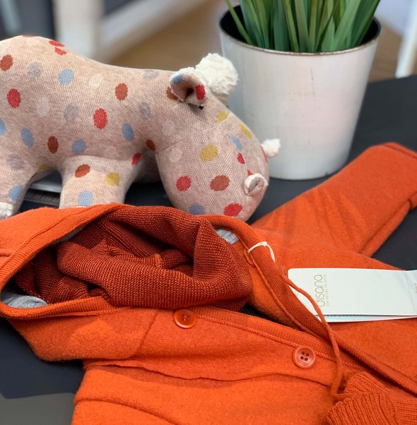 Orange knitted cardigan and toy in the disana shop