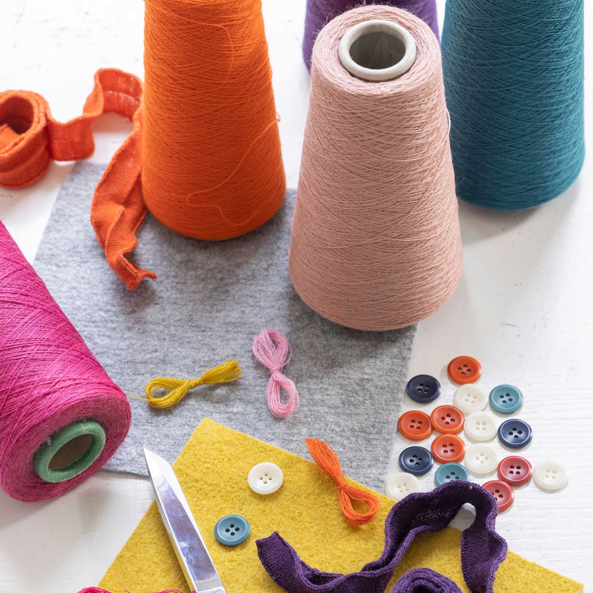 disana Nähzubehör mit Garnspulen in Rosé, Orange und Pacific, bunten Steinnuss-Knöpfen für Care and Repair-Arbeiten