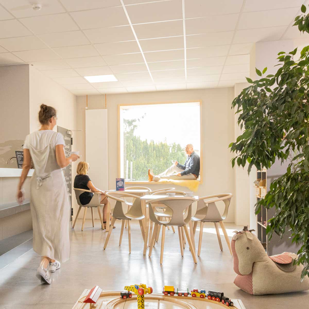 Ladencafé mit Gästen und Spieleisenbahn